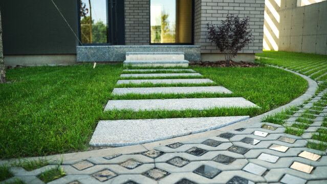 Contemporary house featuring a garden with a paved path, grass stepping stones, and eco-friendly permeable driveway