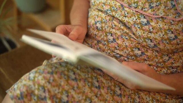 Hands of a woman reading and turning pages of a book closeup