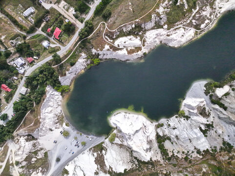Aerial view of Blue Lake with its striking white quartz cliffs and deep blue water surrounded by the rugged landscape of Otago Region, New Zealand.
