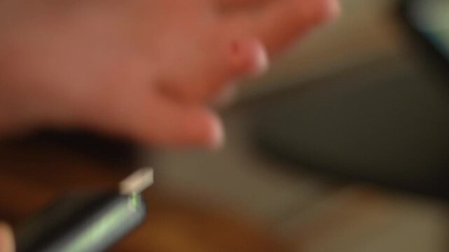 A woman's hand, close-up, measuring insulin or blood sugar with a medicine measuring instrument