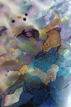 Abstract fluid art pattern in violet tones with brured waves and golden spots