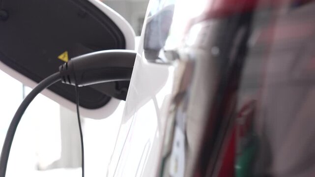 Hand of man unplugs the charging cable of an electric vehicle (EV car), Sustainable clean energy.
