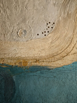 Geological Focus - Combining deep teal slate tones, raw plaster textures, combed ridges, and delicate flecks of gold, the artwork mimics aerial topographies&mdash;where sea meets sand and mineral veins 