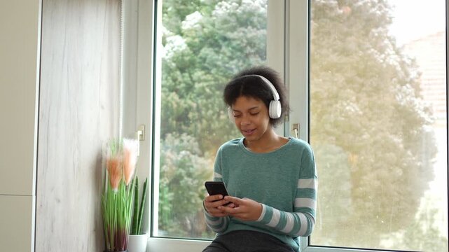 Young woman wearing headphones using smartphone