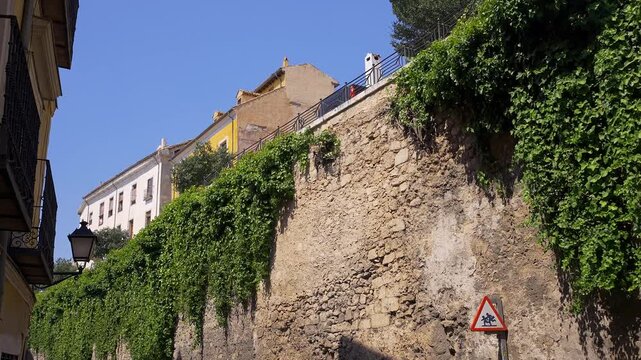 Ivy covered stone wall beneath the historic upper town of Cuenca Spain