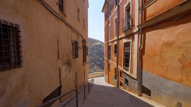 Narrow descending alley between historic buildings in the medieval quarter of Cuenca Spain