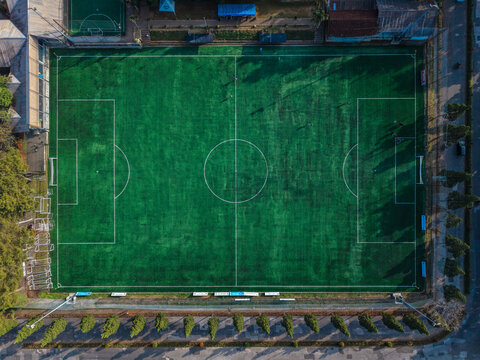 Aerial view of Cihideung soccer field with green artificial turf, white markings, and surrounding trees in Parongpong, West Java, Indonesia.