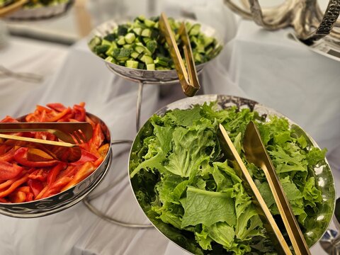 Salad bowls with fresh vegetables placed on a table