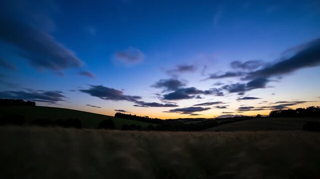 Dramatic sunset sky over rolling countryside landscape