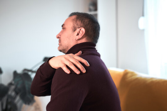 Man with neck, muscle, back and sciatica pain at home.
