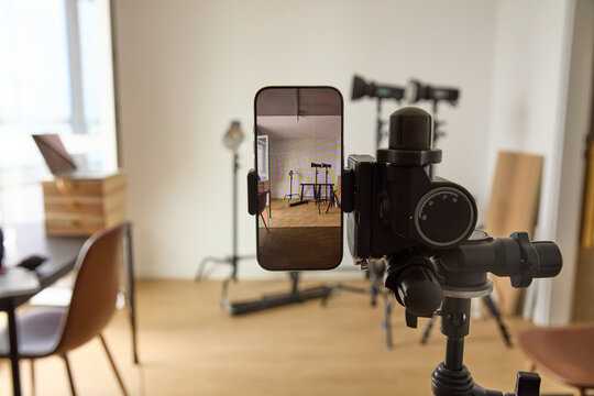 Smartphone mounted on a tripod inside a professional video and photography studio setup