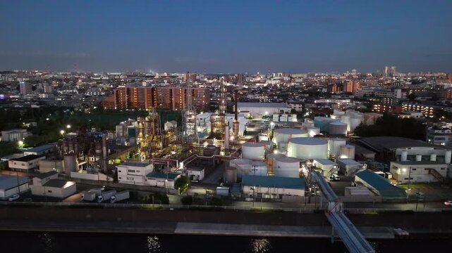 Aerial drone view of industrial factory plant at night near river in Tokyo Japan