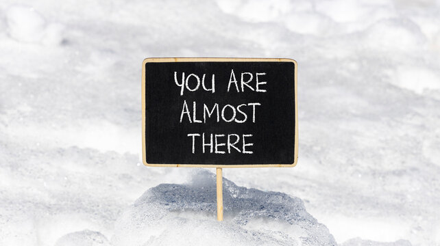 You are almost there words symbol. Concept words You are almost there on beautiful black blackboard. Beautiful snow background. Business You are almost there motivational support concept. Copy space.