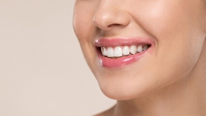 Obraz premium Close-up portrait of a woman with a natural smile showing white teeth, highlighting dental health, oral hygiene, and skincare cosmetics concepts.