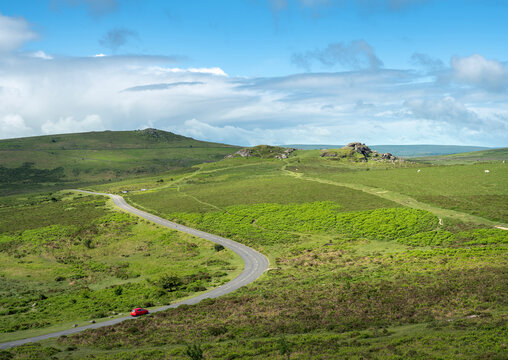 red car on road in dartmoor national park