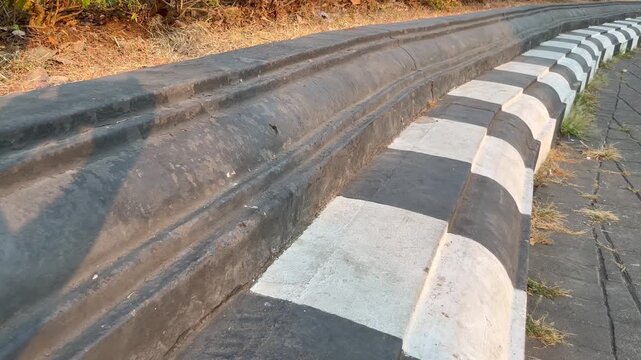 Black and white striped curb stone on the side of the road