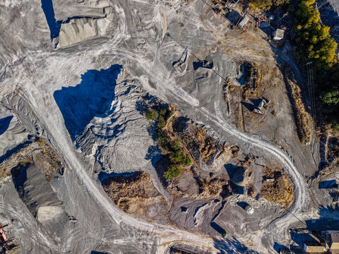 Aerial view of Manton Quarry Road showing gravel piles, excavation paths, and industrial terrain in Calcium, Queensland, Australia.