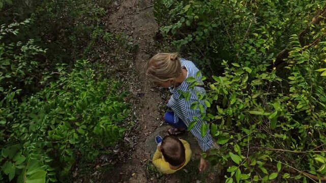 Woman and child walking through thorny bushes