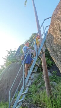 Woman and child go up to large stone