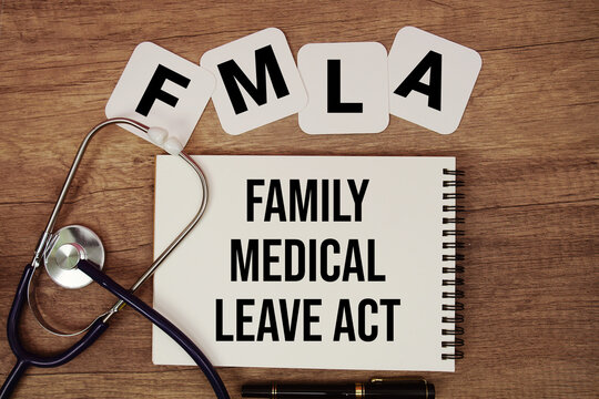 FMLA Family Medical Leave Act text written on notepad with stethoscope on wooden background