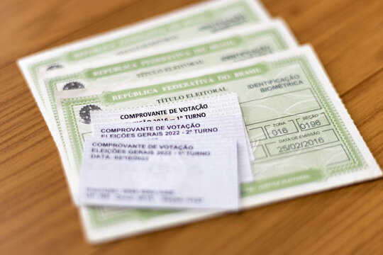 Brazilian voter ID cards (Titulo Eleitoral) with voting receipts from different elections, selective focus