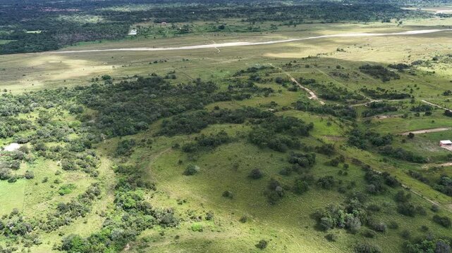Vista a&eacute;rea de dron en movimiento lento sobre paisaje rural con campos verdes y bosques