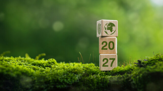 Wooden blocks with 2027 text on green moss, concept of ESG sustainability goals and green business concept for the new year.