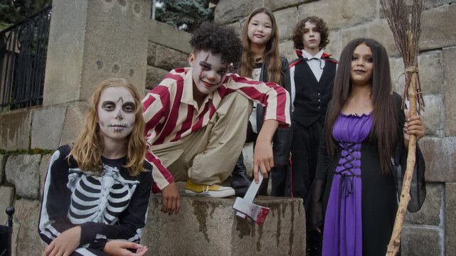Portrait of diverse multiethnic teenagers wearing Halloween costumes and makeup posing outdoors. Footage is ideal for seasonal holiday marketing and event promotions
