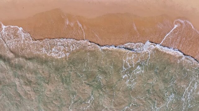 Beautiful sea summer landscape, Waves sea water surface High quality video Bird's eye view, Drone top view waves crashing on sand beach,Nature ocean sea beach background