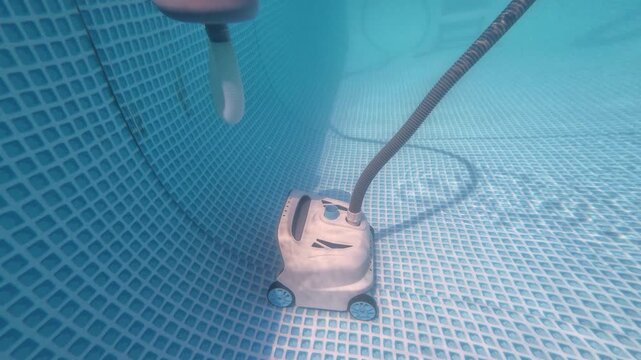 Robotic pool cleaner working underwater to keep swimming pool clean.	