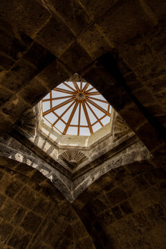 A stone vaulted ceiling with a central modern wooden skylight. Haghartsin Monastery in Armenia.