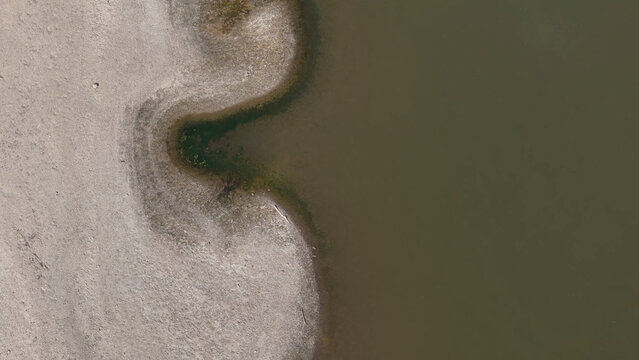 Aerial view of the Po River showing exposed sandbanks and low water levels due to a severe heatwave in Cremona, Lombardy, Italy.