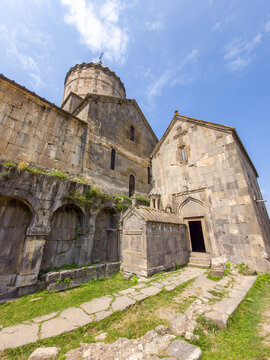 Armenian Tatev monastery complex with arched walkways and open doorway
