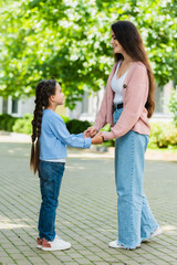 Fototapeta premium Heartwarming moments shared between a mother and her daughter in a sunny park