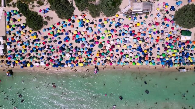 Aerial view of the crowded Torre Lapillo beach in Salento, Porto Cesareo, Puglia, Italy