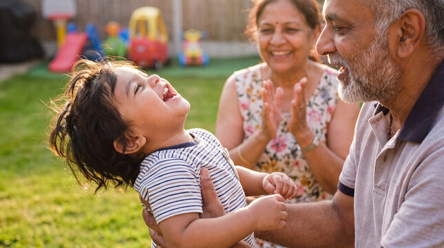 A cheerful toddler plays outdoor games with grandparents in backyard on Grandparents Day for family marketing and cards