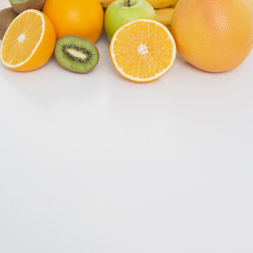 fresh fruit frame with white background. Fresh sliced fruits frame on white background with copy space. Colorful Summer Fruit Border.