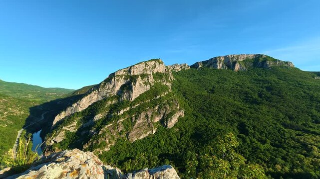 Rocky cliff overlooks deep green valley. Sicevo Gorge, Serbia.