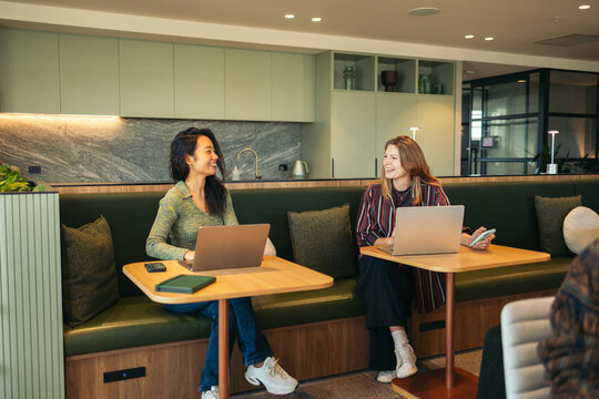 People chatting and working in a coworking lounge