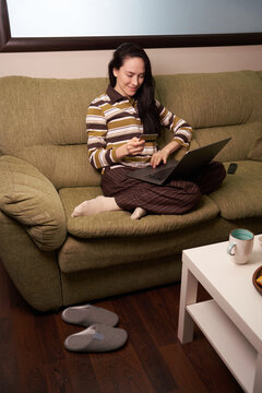 Working on a laptop while sitting on a green couch