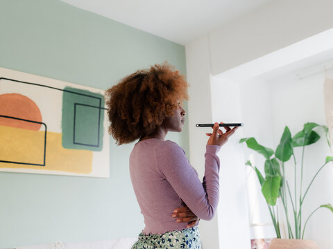 Woman having phone call in living room 