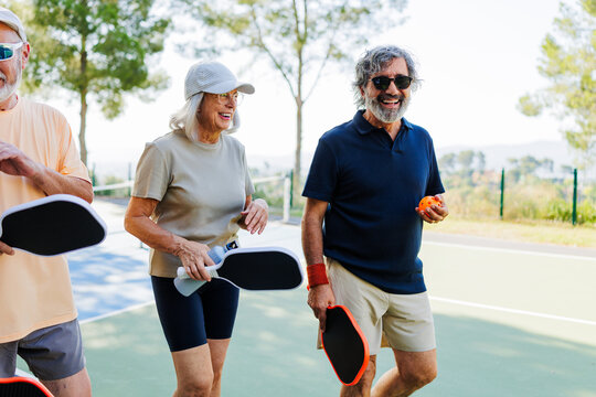 Seniors enjoying pickleball game on outdoor court