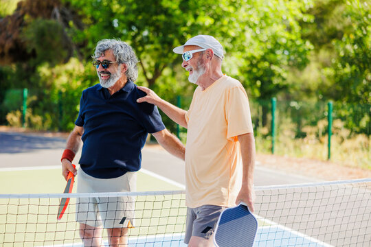 Senior players enjoying active social time on pickleball court