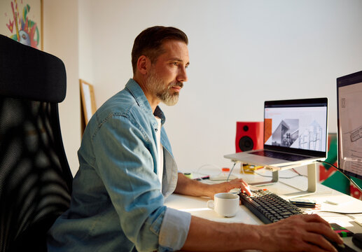 Man works at a desk in the home office.