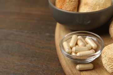 Functional mushrooms and pills on wooden table, closeup. Space for text © New Africa