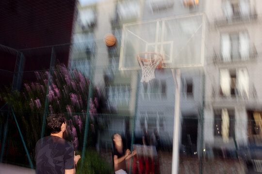 Two young men are playing basketball