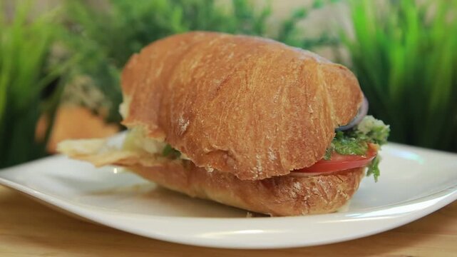 Mediterranean ciabatta sandwich served on a white plate in a kitchen