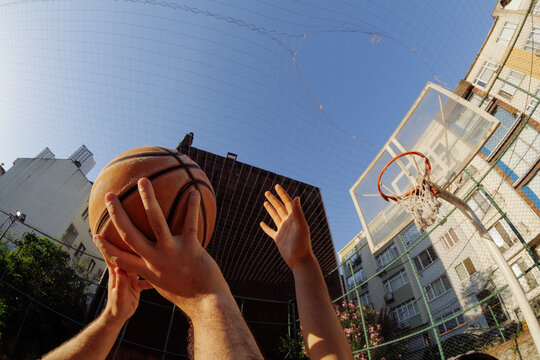 Two young men are playing basketball