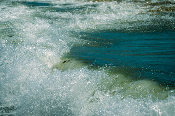 Naklejka premium dynamic ocean waves churning into thick white sea foam as they crash and roll through deep blue water.