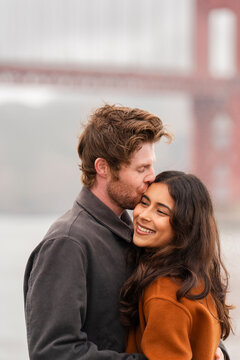 affectionate couple portrait kiss forehead smile